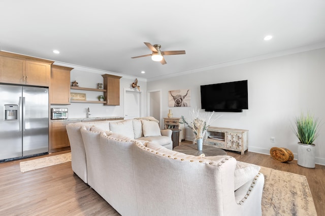 living area with ornamental molding, recessed lighting, and light wood finished floors