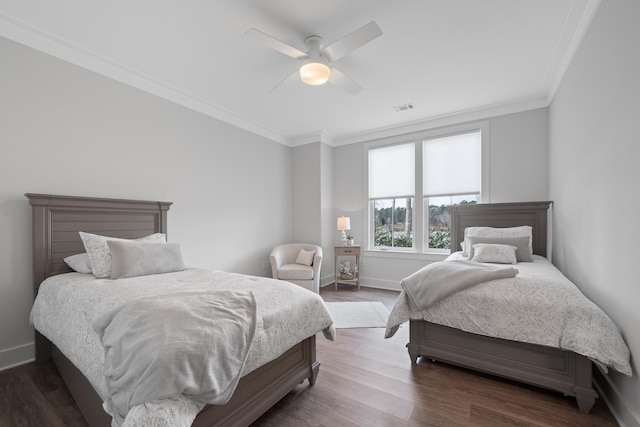 bedroom featuring baseboards, dark wood finished floors, and crown molding