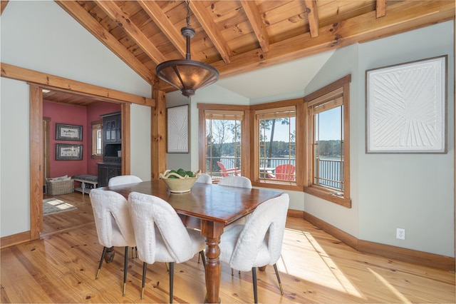 dining space with vaulted ceiling with beams, wooden ceiling, light wood-style flooring, and baseboards