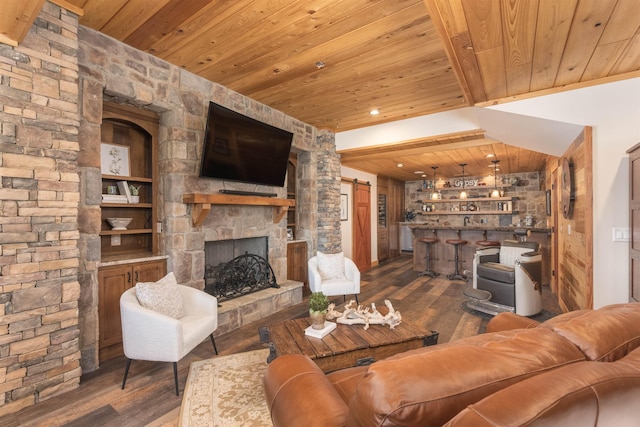 living room featuring a fireplace, a barn door, wood finished floors, wooden ceiling, and bar