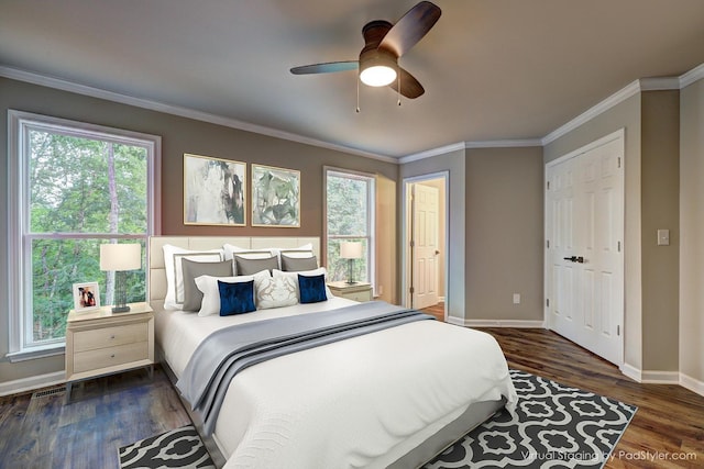 bedroom featuring crown molding, dark wood-type flooring, and ceiling fan