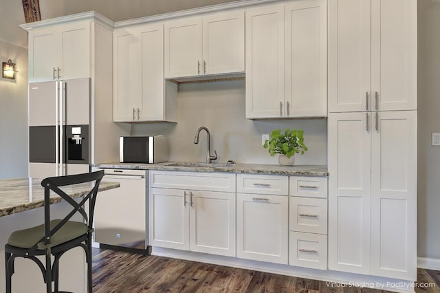 kitchen featuring sink, white cabinets, stainless steel dishwasher, light stone counters, and high end fridge