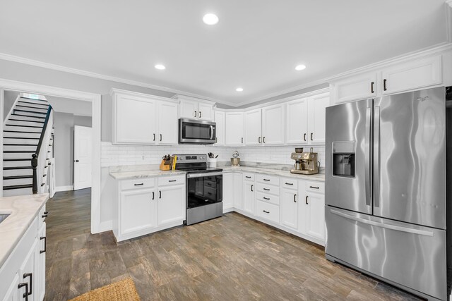 kitchen featuring white cabinetry, ornamental molding, appliances with stainless steel finishes, and light stone counters