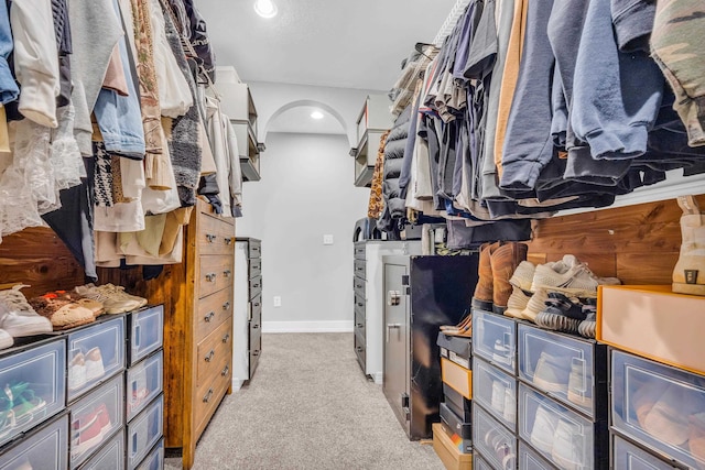 walk in closet with light carpet