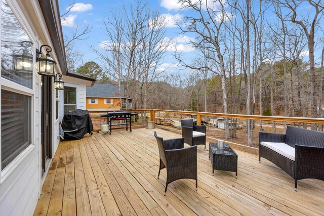 wooden deck featuring an outdoor living space and a grill