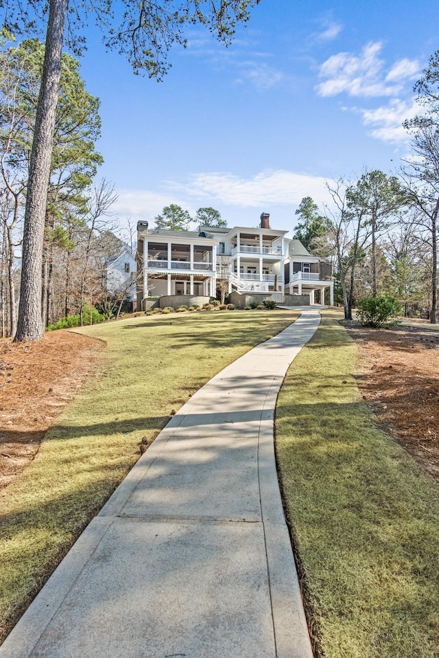 exterior space featuring a yard, a porch, and a chimney