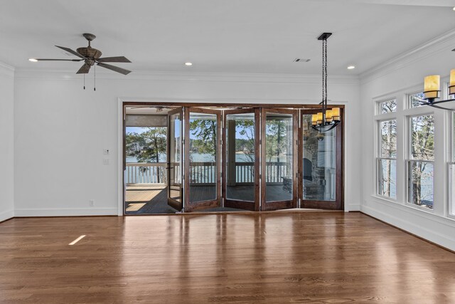 empty room featuring recessed lighting, crown molding, baseboards, and wood finished floors