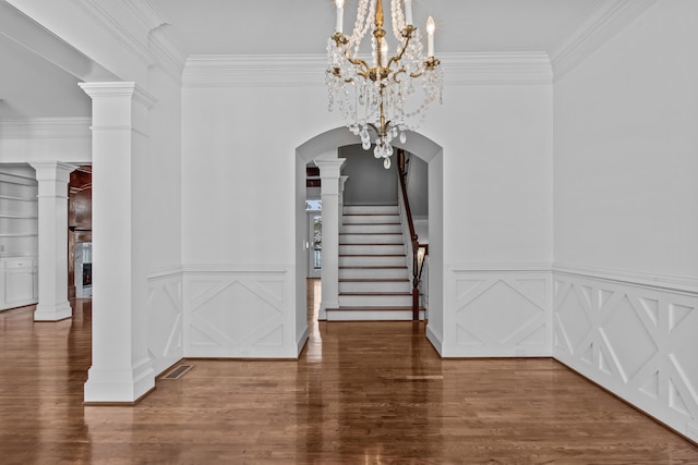 interior space featuring arched walkways, visible vents, wood finished floors, ornate columns, and stairs