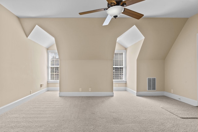 additional living space featuring carpet, visible vents, lofted ceiling, and baseboards