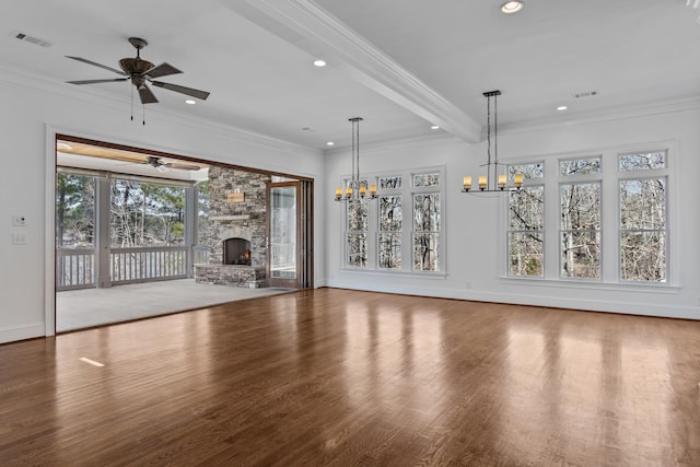 unfurnished living room with crown molding, visible vents, a ceiling fan, a stone fireplace, and wood finished floors