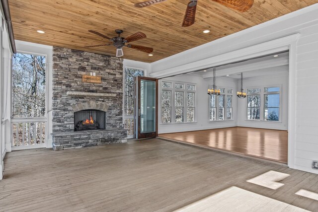 unfurnished living room featuring wooden ceiling, a fireplace, wood finished floors, and ceiling fan with notable chandelier