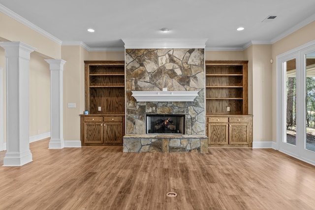 unfurnished living room featuring visible vents, a fireplace, ornate columns, and wood finished floors