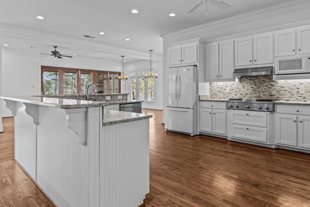 kitchen featuring stainless steel appliances, dark wood-style flooring, under cabinet range hood, and crown molding