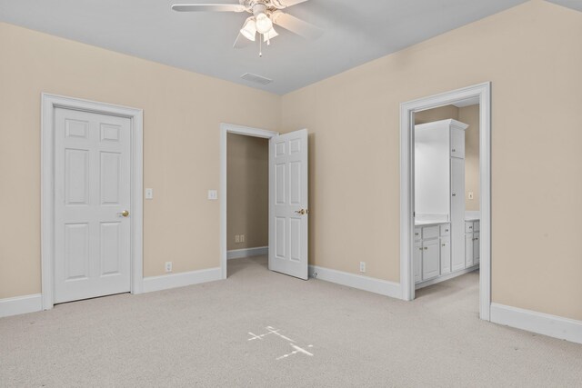 unfurnished bedroom with light carpet, ensuite bath, visible vents, and baseboards