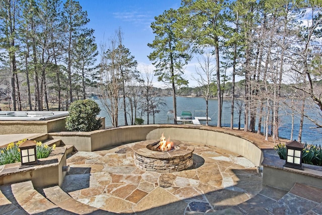 view of patio featuring an outdoor fire pit and a water view