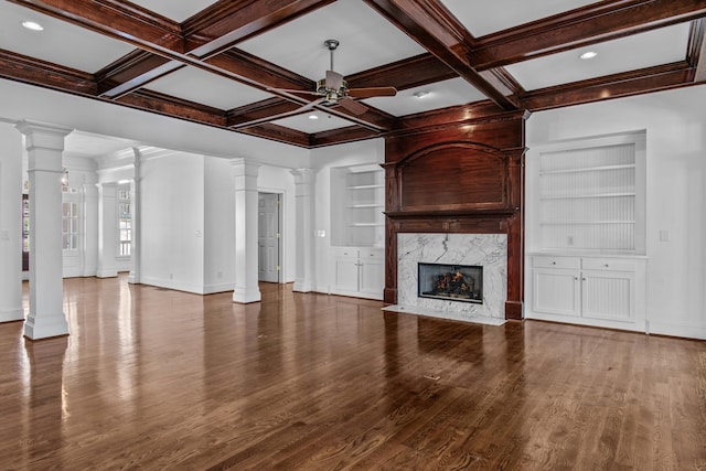 unfurnished living room featuring built in shelves, decorative columns, a premium fireplace, and a ceiling fan