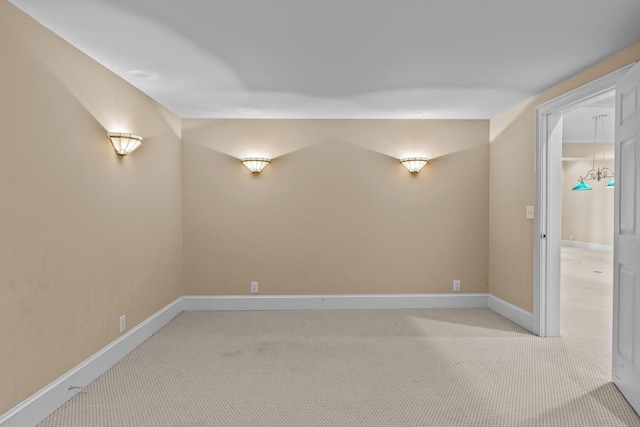 empty room featuring light colored carpet and baseboards