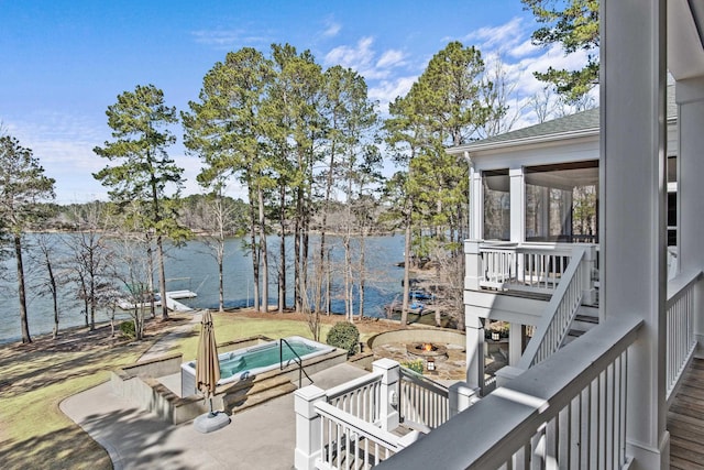 view of patio with an outdoor fire pit, an outdoor hot tub, a sunroom, a water view, and stairs