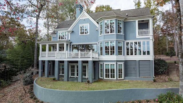 back of house with a yard and a balcony