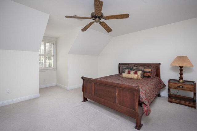 carpeted bedroom with ceiling fan and vaulted ceiling