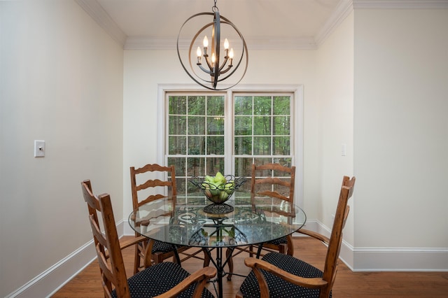 dining space with hardwood / wood-style flooring, ornamental molding, and a chandelier