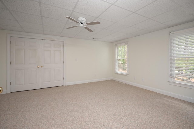 carpeted spare room featuring a paneled ceiling and ceiling fan