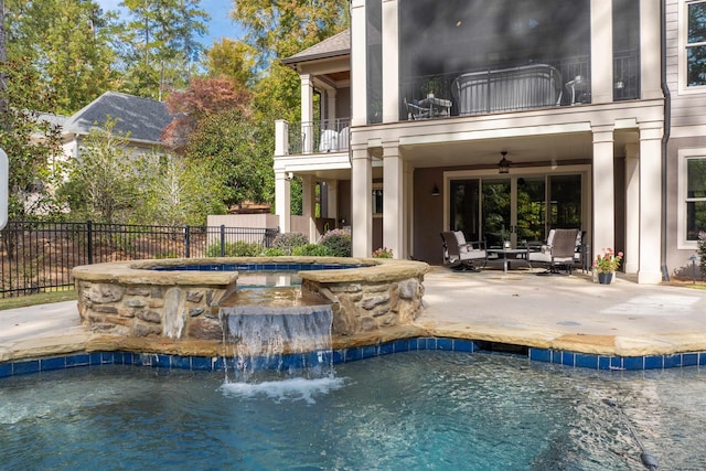 view of swimming pool with an in ground hot tub, ceiling fan, a patio, and pool water feature