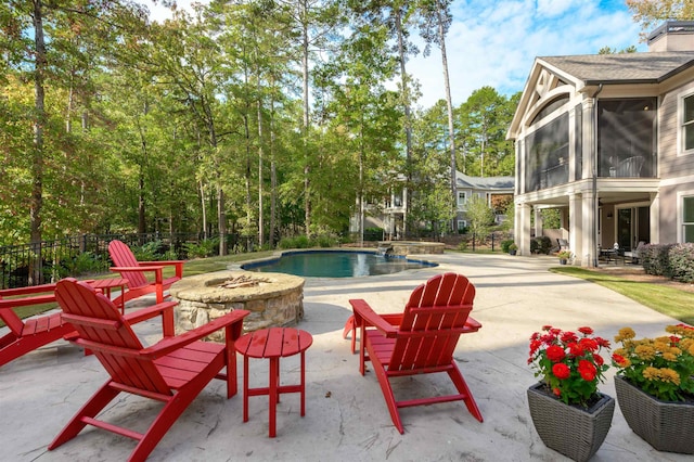 view of pool featuring a patio, a sunroom, and an outdoor fire pit