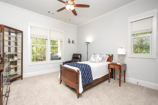 bedroom with multiple windows, crown molding, light carpet, and ceiling fan