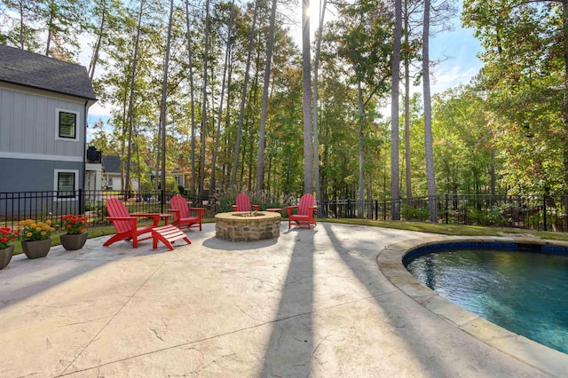 view of patio featuring an outdoor fire pit and a fenced in pool