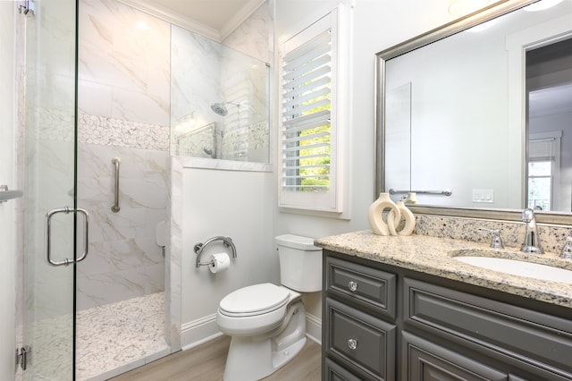 bathroom featuring crown molding, hardwood / wood-style floors, vanity, a shower with shower door, and toilet