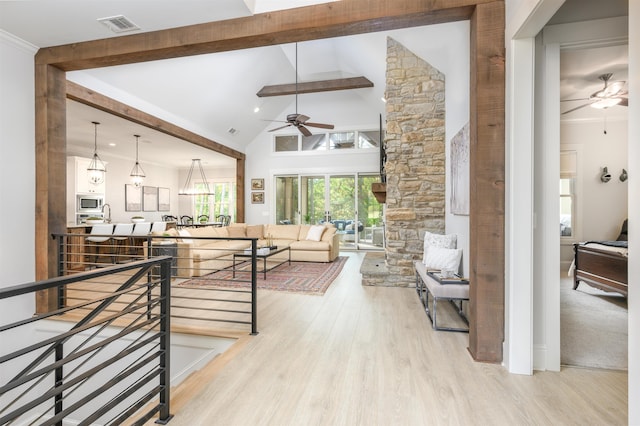 living room featuring beamed ceiling, ceiling fan, high vaulted ceiling, and light hardwood / wood-style flooring