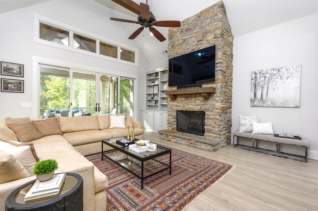 living room with a fireplace, wood-type flooring, high vaulted ceiling, and ceiling fan