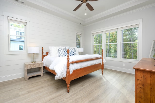 bedroom featuring multiple windows, ornamental molding, ceiling fan, and light hardwood / wood-style floors