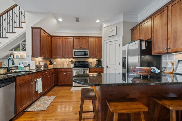 120UNIT304 Indian Summer Path, Eatonton, GA 31024 - kitchen with sink, a breakfast bar, appliances with stainless steel finishes, dark stone countertops, and light wood-type flooring