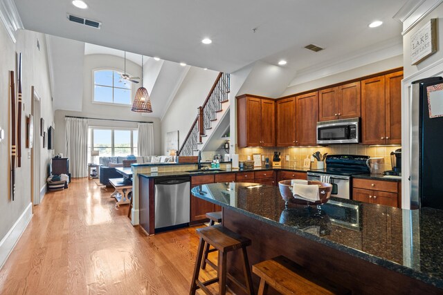 120UNIT304 Indian Summer Path, Eatonton, GA 31024 - kitchen featuring dark stone countertops, appliances with stainless steel finishes, a breakfast bar area, and decorative backsplash