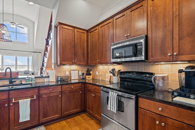 120UNIT304 Indian Summer Path, Eatonton, GA 31024 - kitchen featuring sink, appliances with stainless steel finishes, hanging light fixtures, dark stone counters, and light wood-type flooring