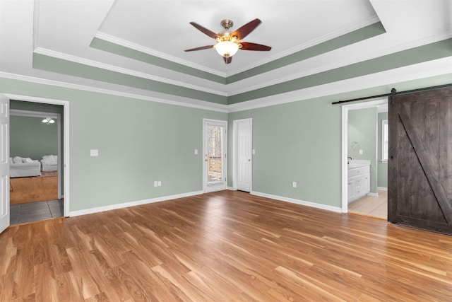 168 N Sugar Creek Rd, Buckhead, GA 30625 - unfurnished bedroom with a raised ceiling, a barn door, light wood-style flooring, and crown molding