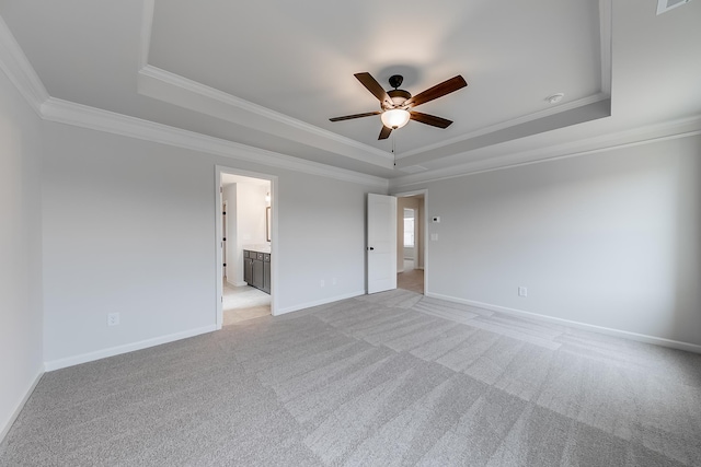 carpeted spare room featuring a tray ceiling, ornamental molding, and ceiling fan