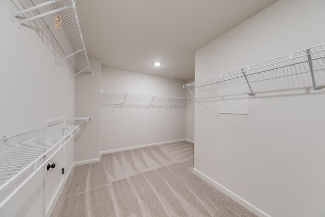 walk in closet featuring light colored carpet