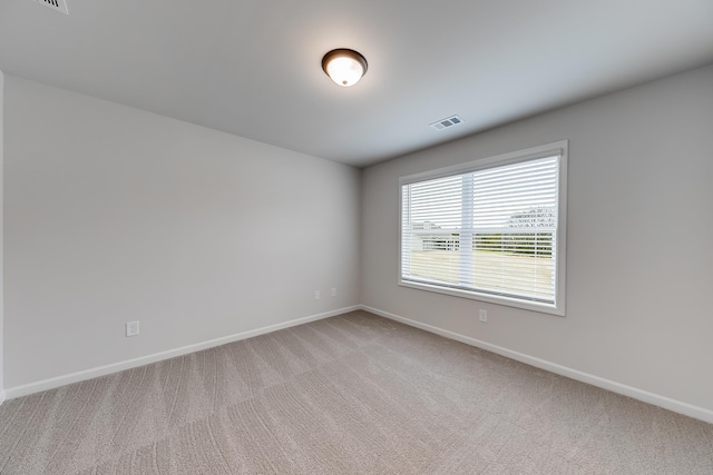 spare room featuring light colored carpet