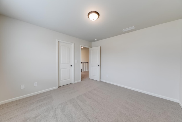 unfurnished room featuring light carpet