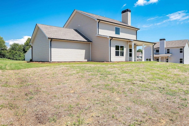 back of house with a lawn