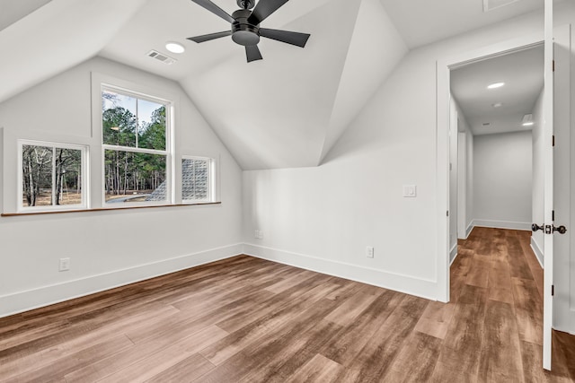additional living space featuring wood finished floors, a ceiling fan, vaulted ceiling, and baseboards