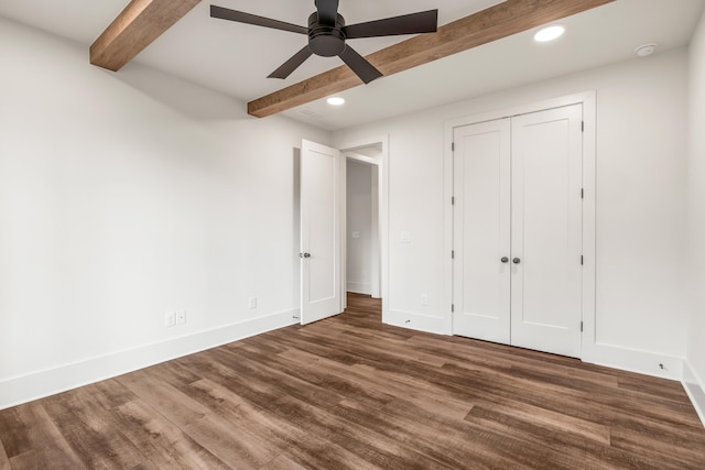 unfurnished bedroom with beam ceiling, recessed lighting, baseboards, wood finished floors, and a closet