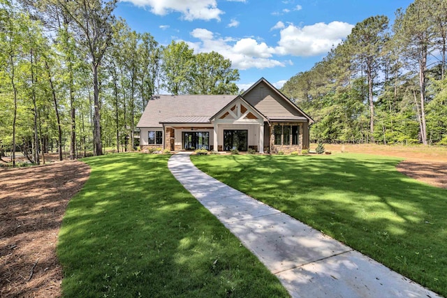 view of front of home with stone siding and a front lawn