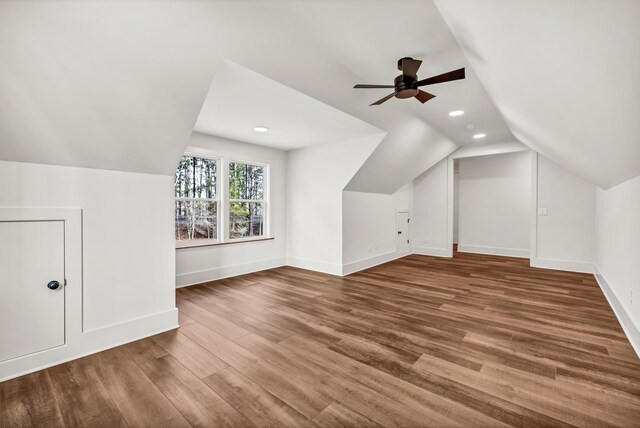 additional living space with vaulted ceiling, baseboards, wood finished floors, a ceiling fan, and recessed lighting
