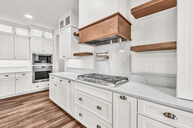 kitchen featuring appliances with stainless steel finishes, open shelves, white cabinetry, glass insert cabinets, and premium range hood