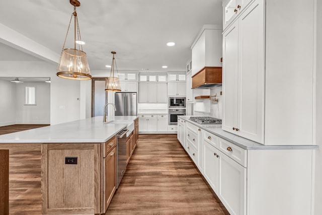kitchen with appliances with stainless steel finishes, recessed lighting, white cabinetry, light countertops, and wood finished floors