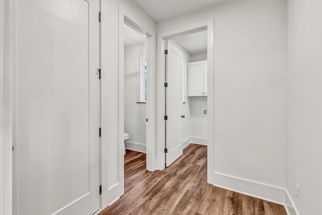 corridor with wood finished floors and baseboards